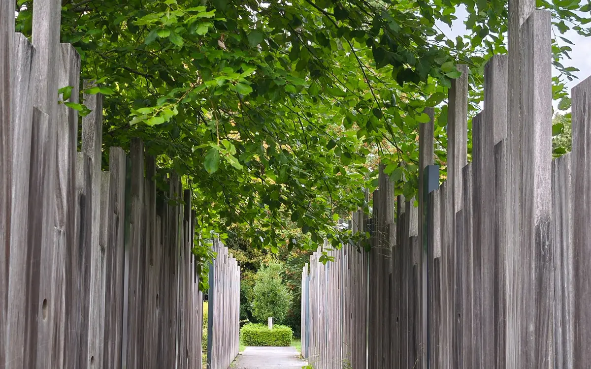 Narrow path between two tall wooden privacy fences of neighboring yards, showing fence placement near a property line in Marion County, Florida