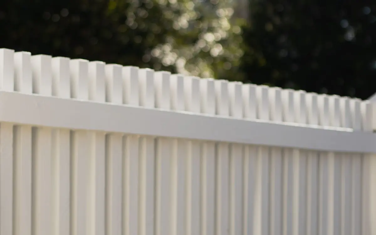 Close-up of a white vinyl privacy fence top